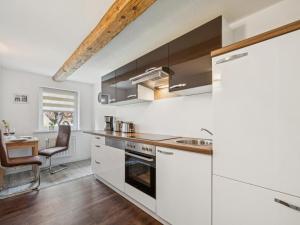 a kitchen with white cabinets and a stove top oven at Modern apartments harz I in Elbingerode