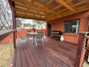 a wooden deck with a table and chairs on it at Snowflakes - Cooma in Cooma