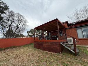 a house with a deck on the side of it at Snowflakes - Cooma in Cooma