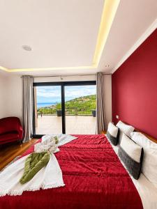 a bedroom with a large red bed with a large window at Villa Livramento in Ponta do Sol +34 photos
