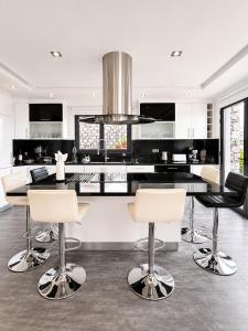 a kitchen with black and white counters and chairs at Villa Livramento in Ponta do Sol