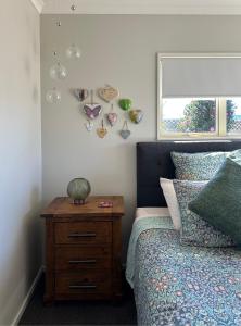 a bedroom with a bed with a wooden nightstand and a window at Studio Haven on Fort in Cambridge