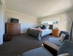 a bedroom with a bed and a dresser and a tv at Studio Haven on Fort in Cambridge
