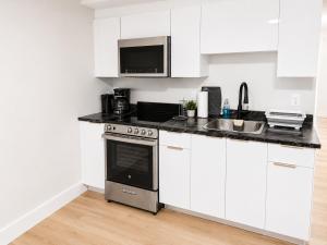 a white kitchen with a stove and a sink at Quiet Haven - One-Bedroom Suite in Riverview