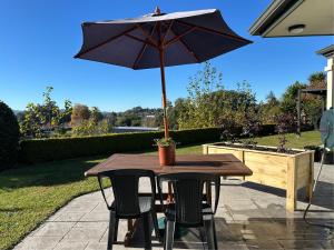 a wooden table with an umbrella on a patio at Studio Haven on Fort in Cambridge