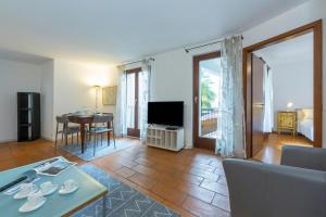 a living room with a couch and a table at Casa Chiara Muralto with Balcony & Wi‑Fi - Happy Rentals in Locarno +11 photos