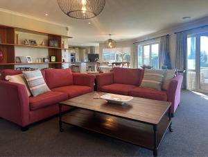 a living room with two red couches and a coffee table at Hideaway on Fort in Cambridge