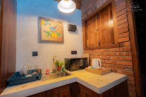 a kitchen with a counter with a sink and a microwave at Heaven's Acres Lodge - Private one Bedroom Cabana in Matale +67 photos