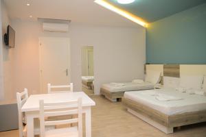 a room with two beds and a table and chairs at Imperial Hotel in Tale +39 photos
