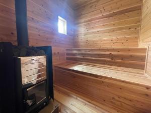a sauna with a wood paneled wall at 古民家宿まるもり in Wada