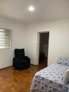 a bedroom with a bed and a black chair at Casa com 1 quarto e 6 camas in Campinas