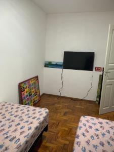 a room with two beds and a flat screen tv at Casa com 1 quarto e 6 camas in Campinas