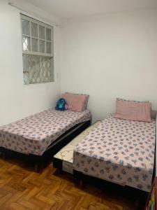 two beds sitting next to each other in a room at Casa com 1 quarto e 6 camas in Campinas