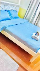 a bed with blue sheets and two slippers on it at Tranquil stays - 1 modern 1 bedroom apartment along Kandunyi Highway in Longonot
