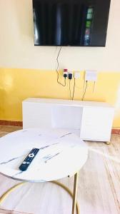 a tv on top of a table with a remote control at Tranquil stays - 1 modern 1 bedroom apartment along Kandunyi Highway in Longonot