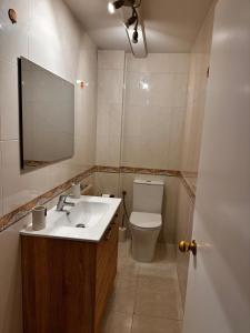 a bathroom with a sink and a toilet and a mirror at Rincón Atlántico ático deluxe in Moaña
