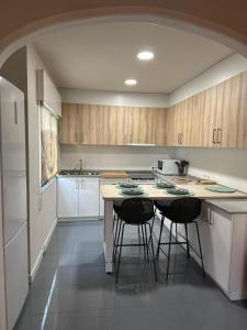 a kitchen with a counter and stools in it at Rincón Atlántico ático deluxe in Moaña