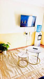 a living room with two tables and a tv at Tranquil stays - 1 modern 1 bedroom apartment along Kandunyi Highway in Longonot