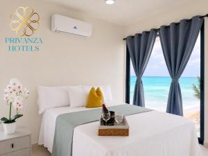 two beds in a bedroom with a view of the ocean at Privanza Hotels in Santa Cruz de Barahona