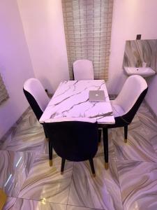 a table and chairs with a laptop on top of it at Velaris Luxury Apartment in Port Harcourt