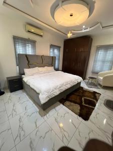 a bedroom with a large bed and a living room at Velaris Luxury Apartment in Port Harcourt