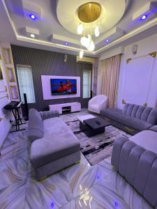 a large living room with couches and a tv at Velaris Luxury Apartment in Port Harcourt
