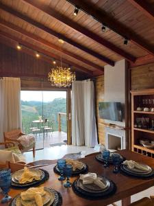 a living room with a table and a chandelier at Chalé Pazinato in Venda Nova do Imigrante +16 photos