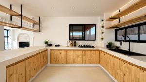 a kitchen with wooden cabinets and white walls at Villa Atlantica - Preá in Prea +22 photos