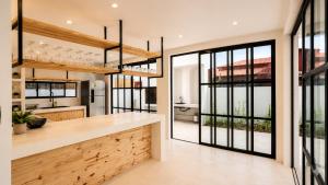 a kitchen with large windows and a large kitchen island at Villa Atlantica - Preá in Prea