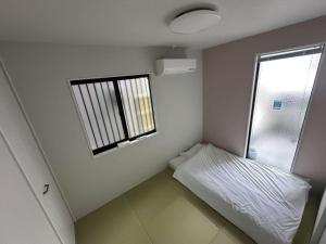 a small room with a bed and a window at ドリームホテル住吉 in Sumiyoshi