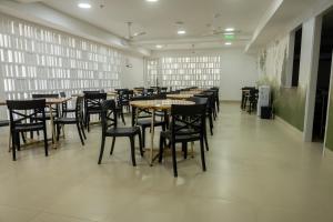 a dining room with tables and chairs and windows at Student Site - Coliving Hotel in Montería +12 photos