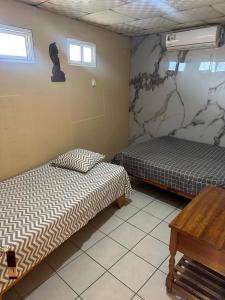 a room with two beds and a table in it at Cabinas Hilda in Canoas