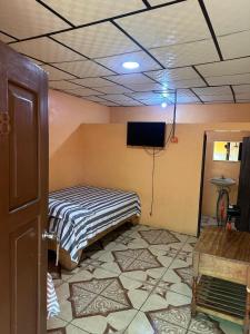 a room with a bed and a flat screen tv at Cabinas Hilda in Canoas