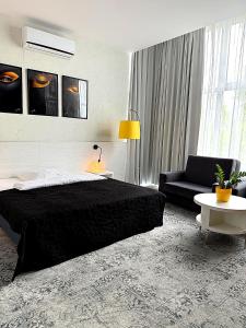 a bedroom with a black bed and a couch at Hotel Absolwent in Gostyń