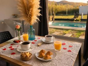 a table with a breakfast of coffee and orange juice at AROMA DEL POTRERO PISCINA CLIMATIZADA CUBIERTA disponible desde Septiembre in Potrero de los Funes