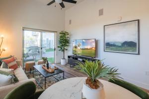 a living room with a couch and a tv at Rooftop Deck, Heated Pool Nearby Golf & Sun Stay in Scottsdale