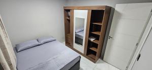 a small room with a bed and a small cabinet at RG Kitnet05 in Curitiba