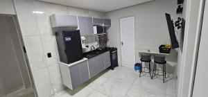 a small kitchen with a refrigerator and a counter at RG Kitnet05 in Curitiba
