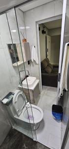 a small bathroom with a toilet and a sink at RG Kitnet05 in Curitiba