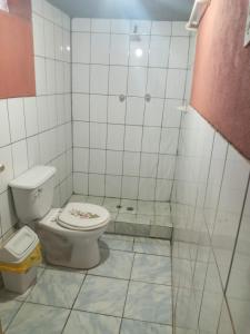 a white bathroom with a toilet and a shower at Hospedaje jatari in Estanciasuyo