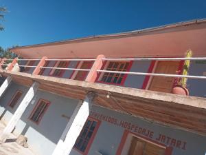 an old building with red and white windows at Hospedaje jatari in Estanciasuyo +6 photos