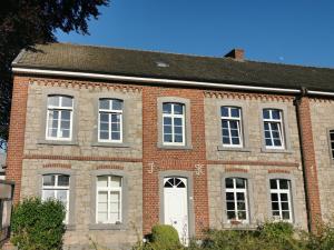 an old brick house with a white door at Charmante Ferienwohnung in einem Bauernhaus in Lontzen