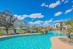 a swimming pool at a resort with chairs and trees at King Bed Remodeled and Walkable Adjacent Kierland Golf in Scottsdale