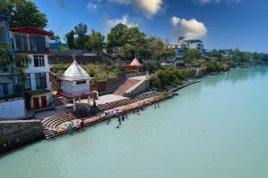 a group of people standing on a dock on a river at hotel tripta ganga in Rishīkesh