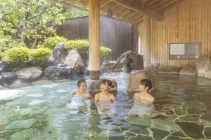 three children swimming in a pool in a garden at Ooedo Onsen Monogatari Premium Saiki Bekkan in Misasa
