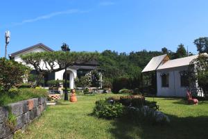 a yard with a house and a retaining wall at Sarah's Small Garden in Cheonan