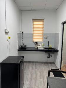 a kitchen with a black counter and a window at DNH Nilam Puri Homestay Unit B in Kota Bharu