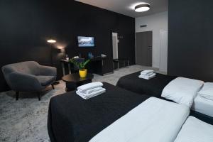 a hotel room with two beds and a chair at Hotel Absolwent in Gostyń +140 photos