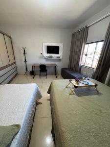a hotel room with two beds and a tv at Studio Lindo no coração de Picos in Picos