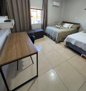 a hotel room with two beds and a table at Studio Lindo no coração de Picos in Picos